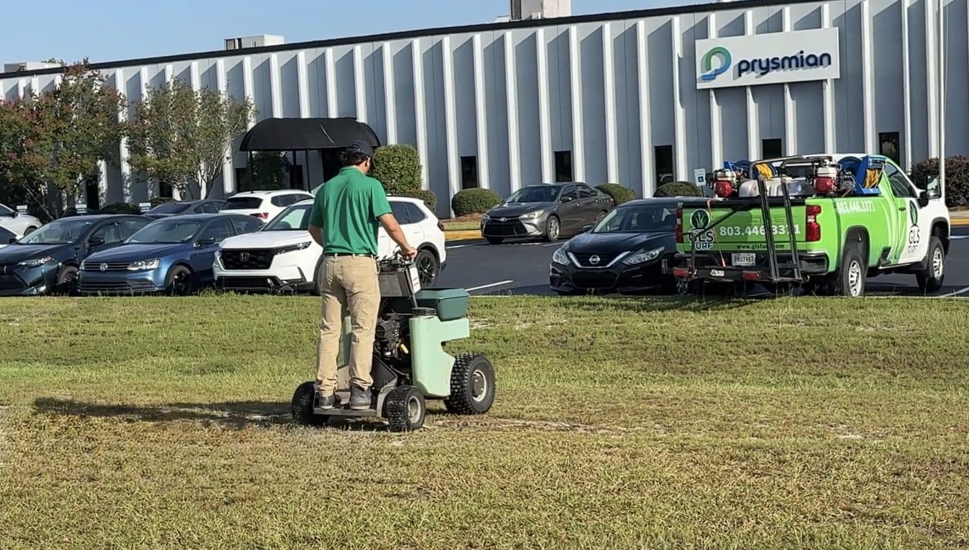 GLS Turf technician applying a granular treatment with a stand-on spreader in Lexington, South Carolina