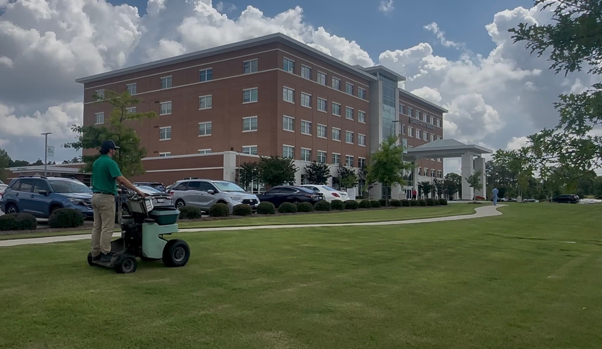 GLS Turf technician applying fertilizer treatment at a hospital campus in Columbia, South Carolina