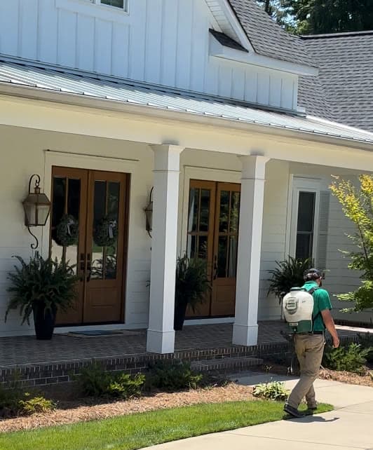 GLS Turf technician applying weed control spray on a residential lawn