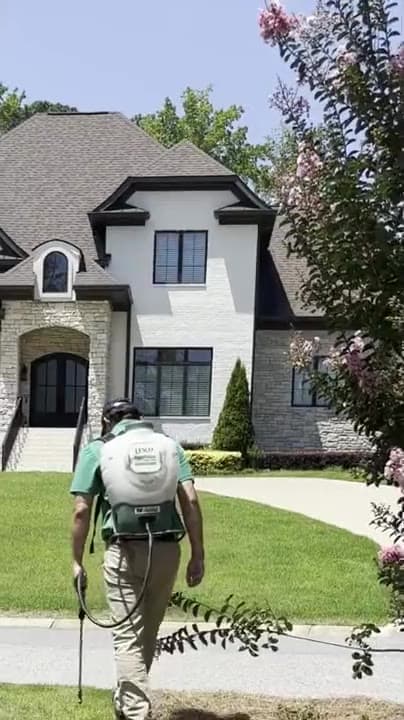 GLS Turf technician spot-treating weeds with a backpack sprayer at a Lexington, South Carolina home