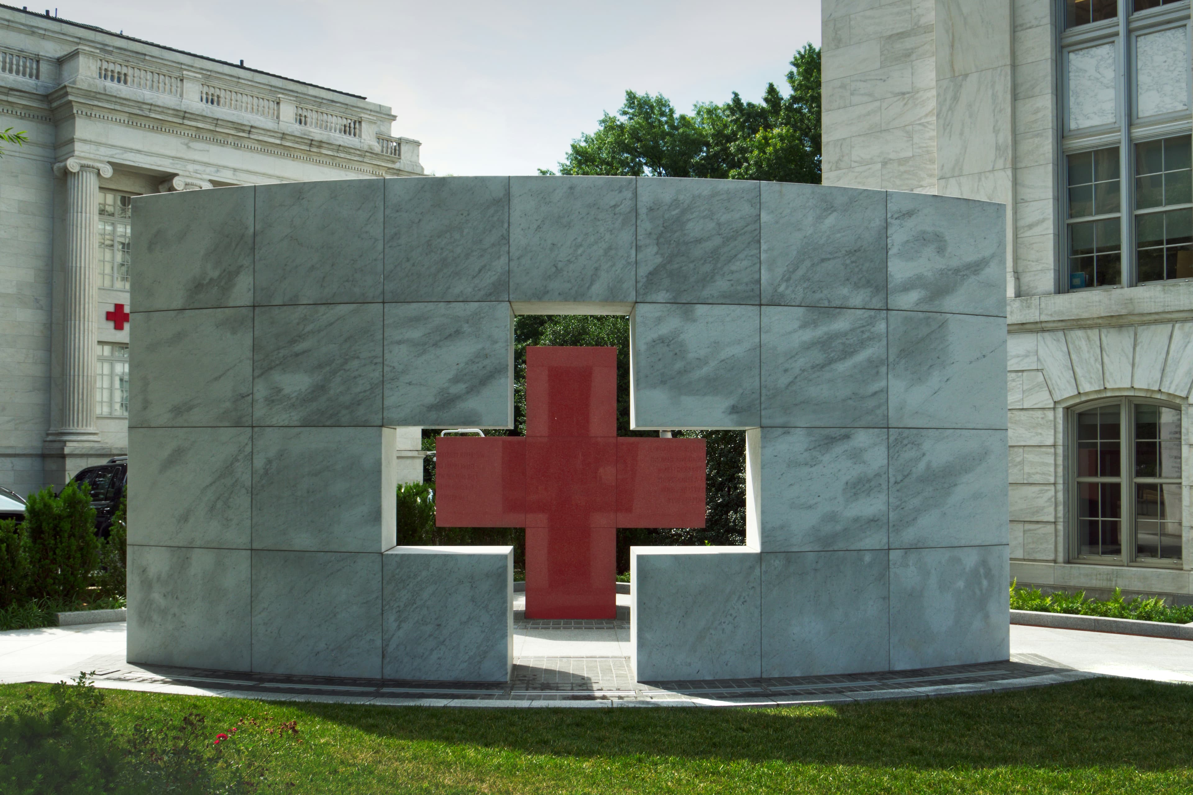 Healthcare campus grounds with manicured lawn around a Red Cross monument